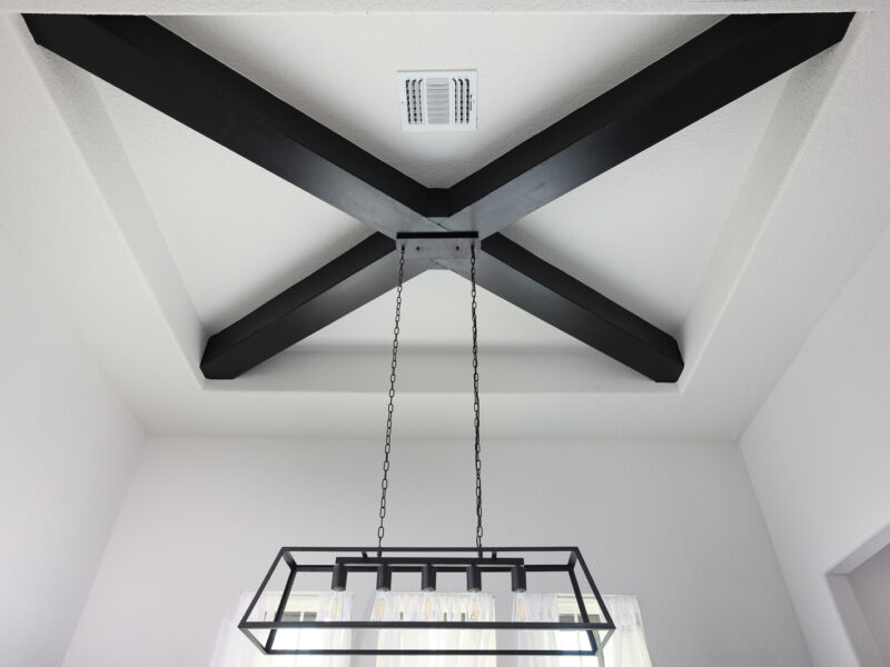 Exposed ceiling beams and dining room light fixture