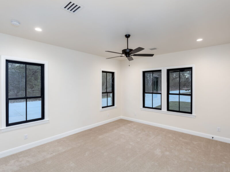 Bedroom with ceiling fan and black-framed windows