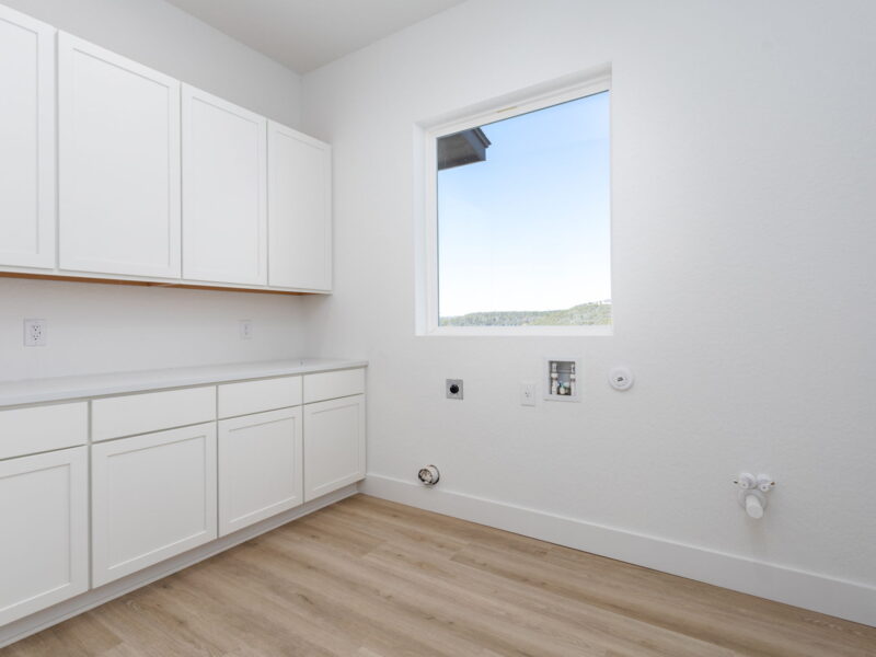 Laundry room with white cabinets and a Hill Country view