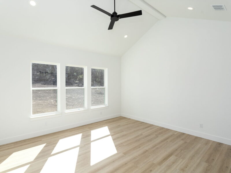 Bright bedroom with windows and a ceiling fan