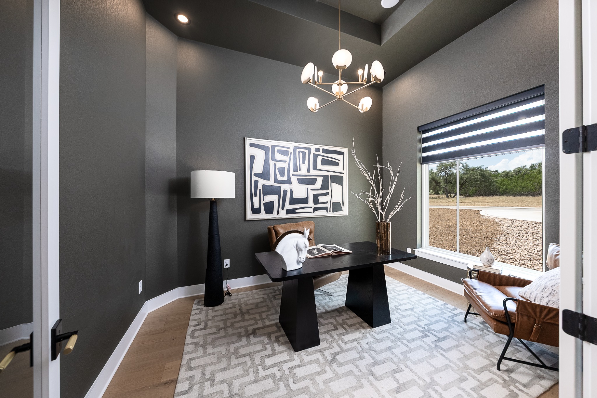 Home office with dark walls and large window