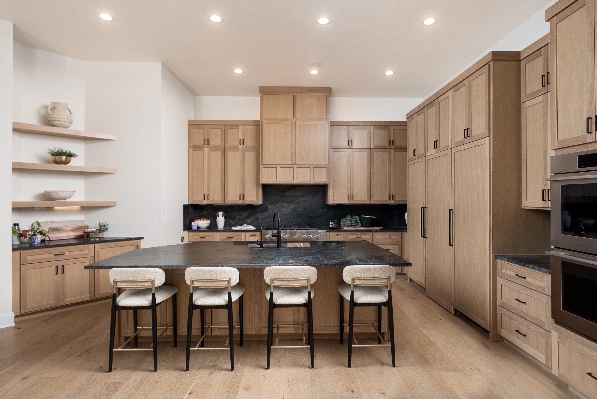 Kitchen with wood cabinetry and dark stone island