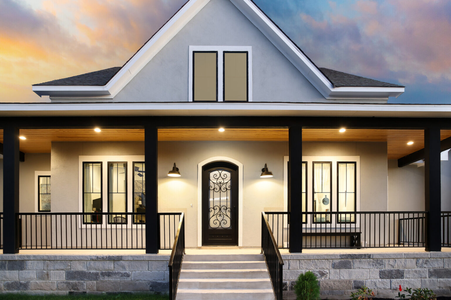 Welcoming front porch of a Macaw Homes custom home at sunset